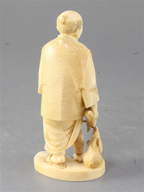 A Japanese ivory okimono of a farmer and two rabbits, early 20th century, height 16.5cm, repairs